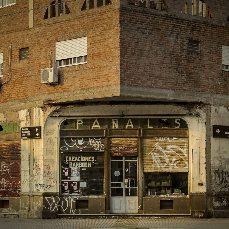 Alter, verlassener Laden mit dem Namen "PANALES" und graffitibedeckter Fassade in urbaner Umgebung. Lost Place, alternative Stadtführung.